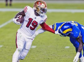 Deebo Samuel from the San Francisco 49ers stiff arms a defender from the LA Rams during an NFC West divisional tilt in 2021. (Image: Getty)